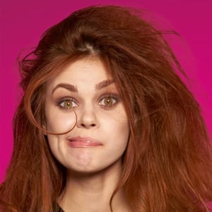 a young woman looks at the camera and appears resigned to her messy hair