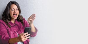 A happy young woman in a magenta denim jacket signs 